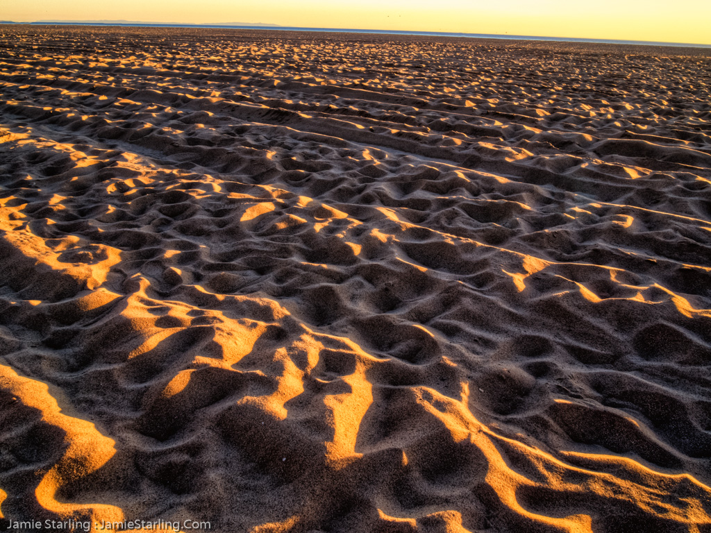 A breathtaking view of undulating sand dunes illuminated by sunset, representing life's beauty and the resilience required to navigate its complexities.