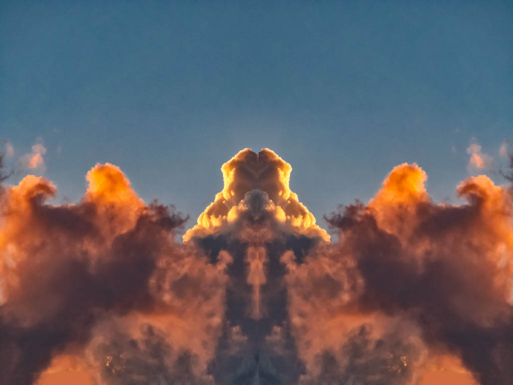 A thought-provoking image showing clouds in Raleigh with fiery edges, mirrored to form a symmetrical pattern, embodying the human struggle to find order in chaos.