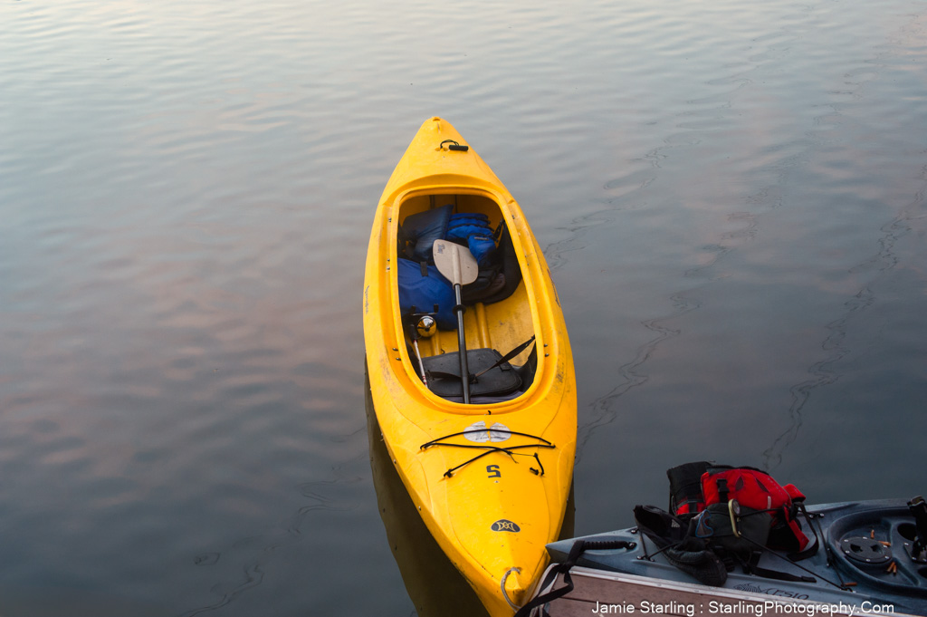 A vibrant yellow kayak waiting on tranquil waters, symbolizing the journey toward inner peace and the stillness we all seek.