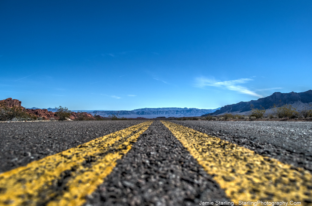 An open road stretching into the horizon under a clear blue sky, symbolizing the journey of finding your path and embracing the endless possibilities ahead.