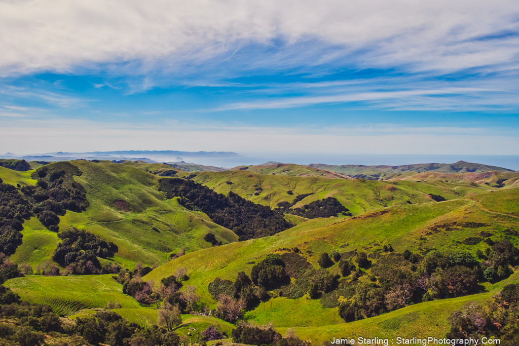 A captivating view of lush green hills beneath a wide, clear blue sky, embodying growth and the vast potential of life's journey, encouraging viewers to explore their own inner landscapes and hidden needs.