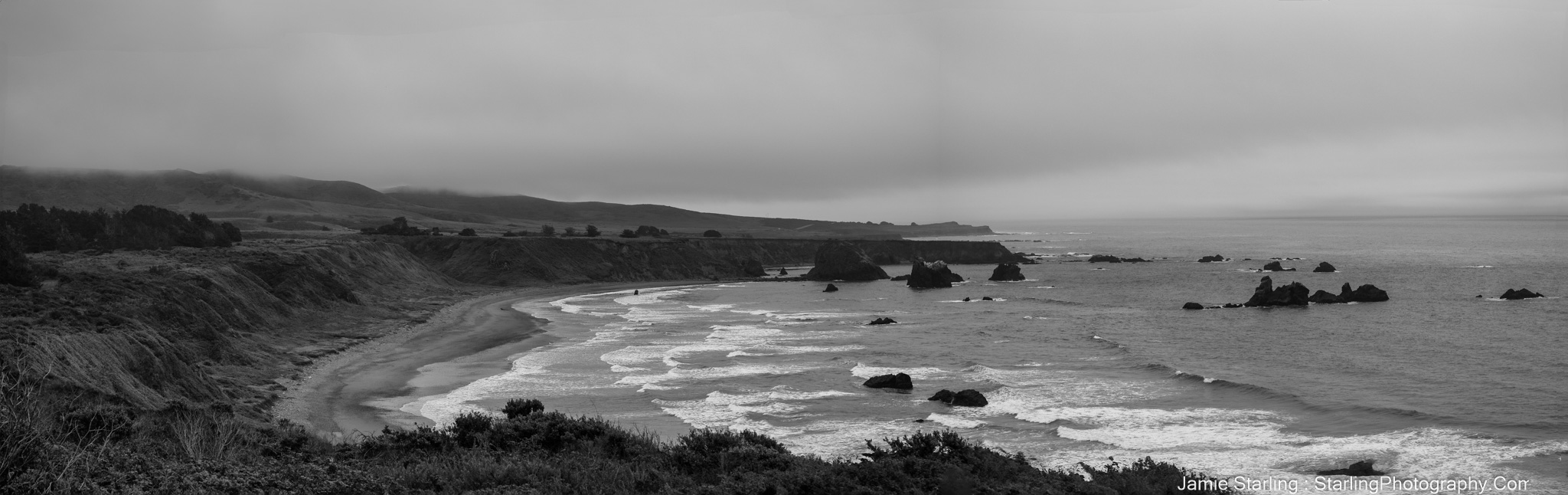 A peaceful black and white coastal landscape with gentle waves, misty horizons, and rocky shorelines, symbolizing life's rhythms, challenges, and resilience, compelling viewers to explore their inner peace and strength.