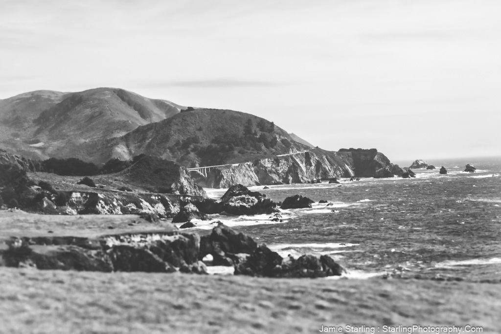 A captivating black-and-white coastal landscape with rugged cliffs and serene ocean waves, symbolizing the journey of life and the beauty in both calm and tumultuous moments.