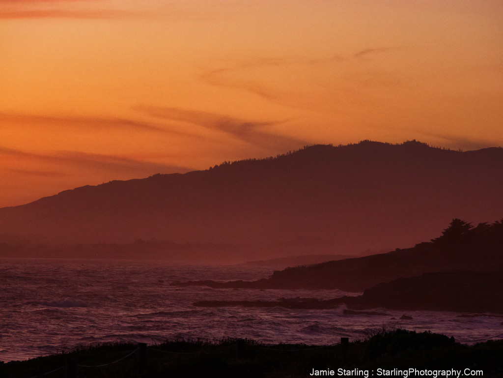 A beautiful sunset over a peaceful coastal landscape with orange and red hues reflecting off the ocean, symbolizing the balance between chaos and peace.