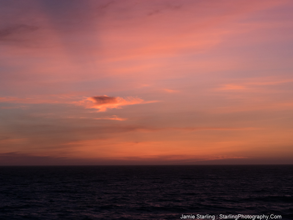 An awe-inspiring sunset with pink and orange hues over the horizon, evoking thoughts on the quest for truth and the beauty of life's journey.