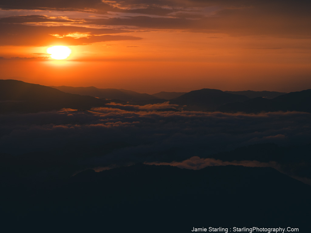 Warm sunset over rolling hills with clouds, symbolizing life transitions and the journey toward new beginnings and deeper understanding.