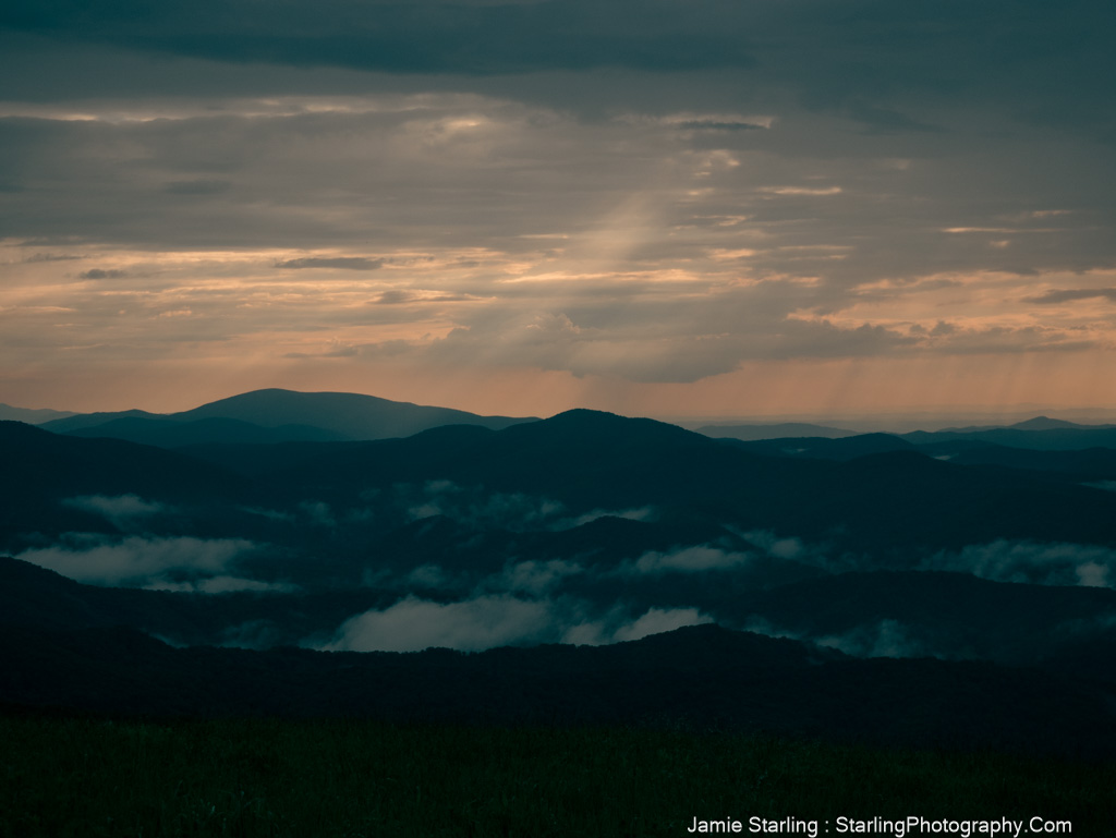 Evening light breaking through misty mountains, symbolizing the beginning of awakening and the clarity that follows.