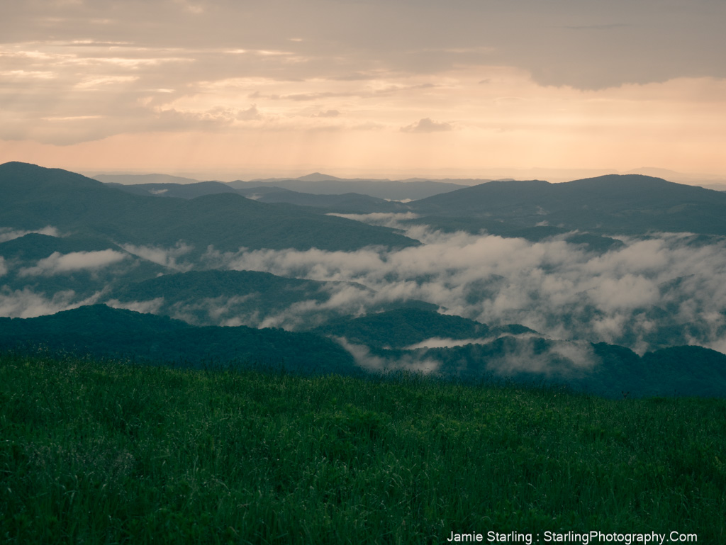 Layered mountains with fog and light breaking through, symbolizing the journey to break free from societal confines and discover true freedom.