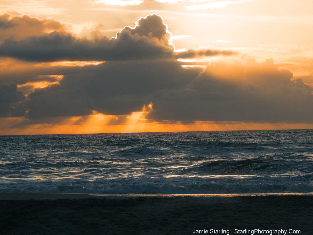 Sunlight breaking through dark clouds over the ocean, symbolizing the journey from external guidance to personal wisdom.