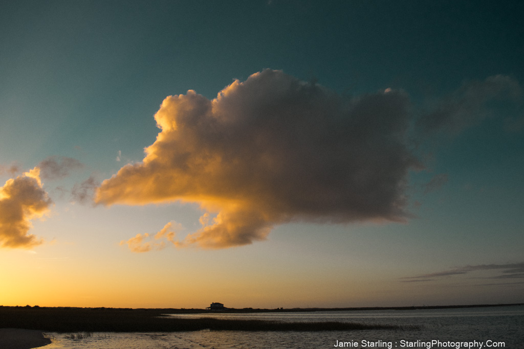 A golden cloud illuminated by the setting sun, floating freely in the sky, symbolizing the journey to self-acceptance and authentic living.