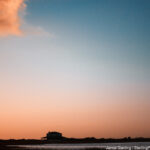 A solitary house under a vast, colorful sky, symbolizing the smallness of the ego compared to the limitless nature of our true self, inviting viewers to reflect on their own journey beyond the ego.