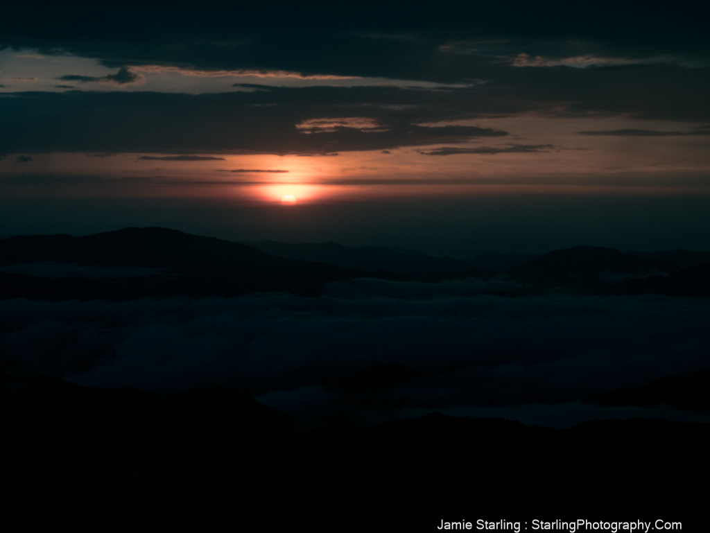 A serene twilight scene with the sun setting behind mountains, creating a captivating balance of light and darkness that invites reflection and exploration.