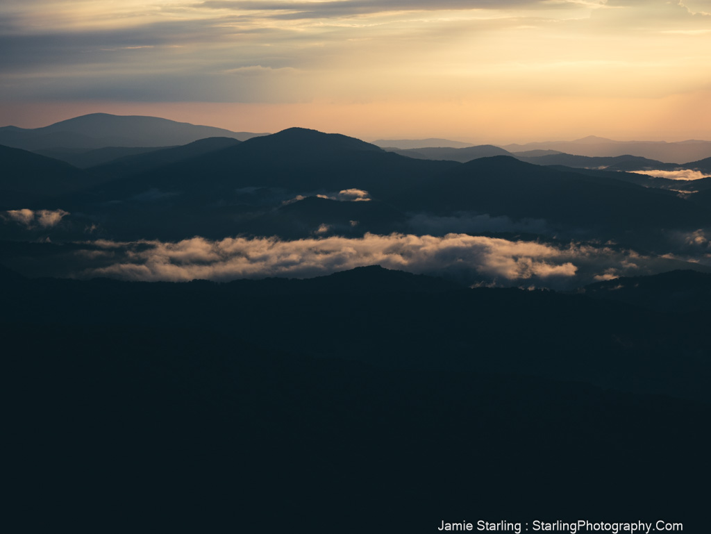 A tranquil mountain range at dawn with soft light and lingering mist, symbolizing the journey of waking up to your own creative vision in photography.