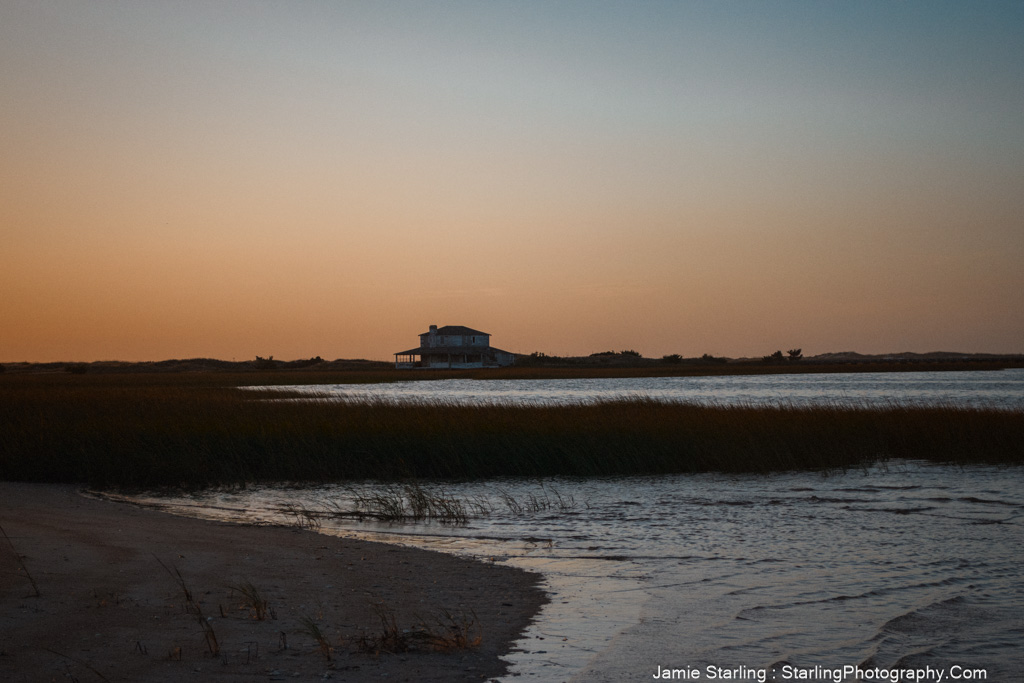 A serene house by the water at sunset, reflecting tranquility and solitude, showcasing the emotional depth that can be captured in photography.