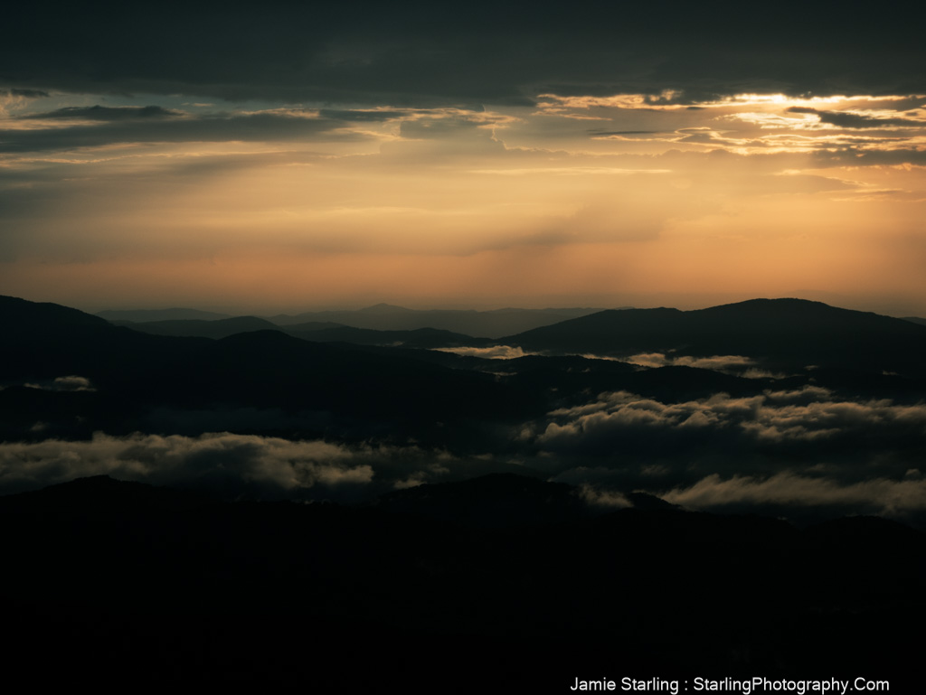 A serene mountain range at dusk with soft light breaking through clouds, symbolizing the moments of clarity that reveal the truth beyond life's illusions.