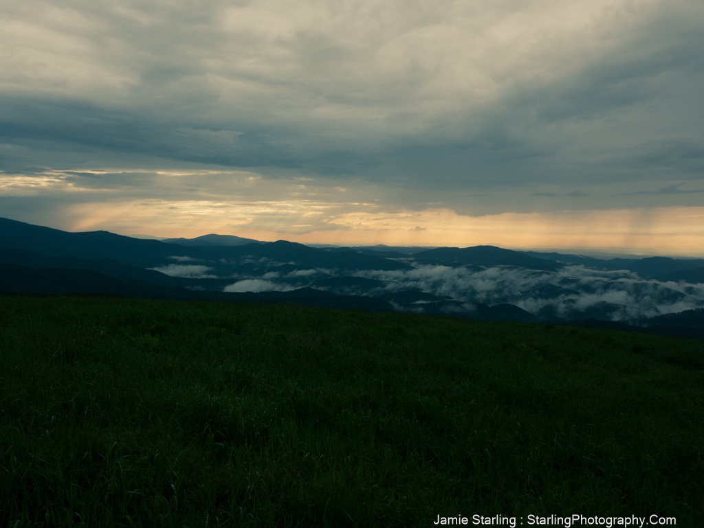 Tranquil dusk over rolling hills with low-lying clouds, symbolizing emotional depth and the journey of self-discovery in photography.