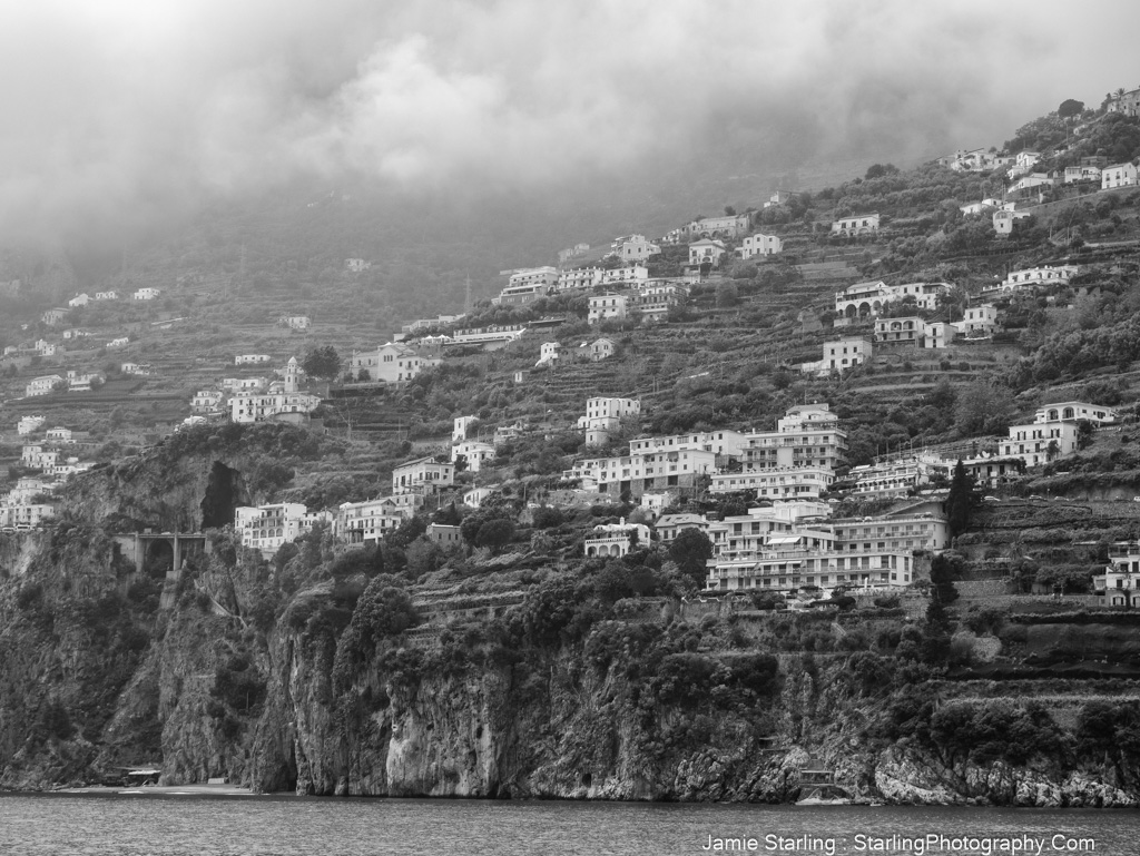 A misty mountainside village with homes rising toward the clouds, symbolizing life's journey of balance, growth, and connection.